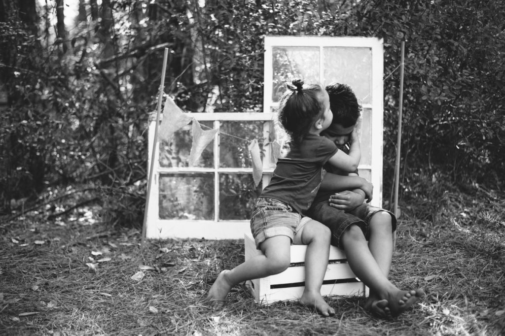 siblings kiss black and white